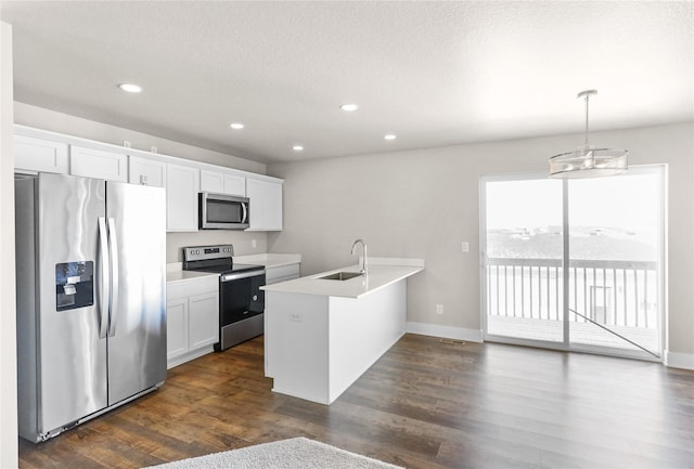 kitchen with stainless steel appliances, dark wood-type flooring, a sink, and a peninsula