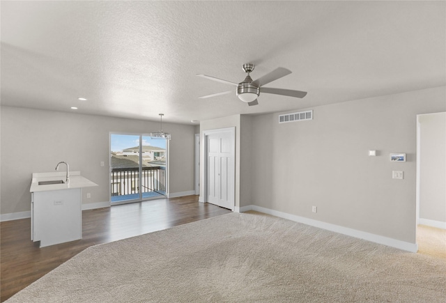 unfurnished room featuring baseboards, a textured ceiling, visible vents, and a sink