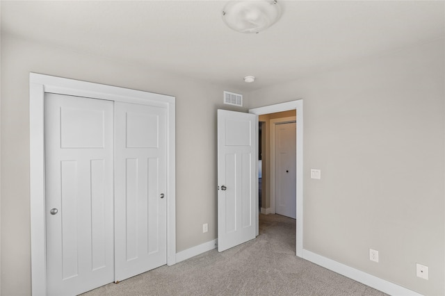 unfurnished bedroom featuring light colored carpet, a closet, visible vents, and baseboards