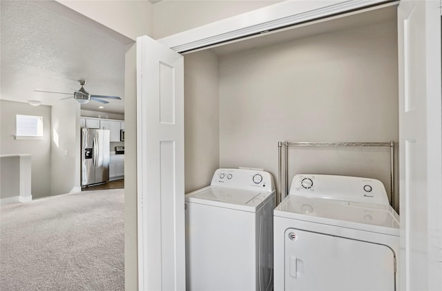 clothes washing area featuring laundry area, washer and clothes dryer, a ceiling fan, a textured ceiling, and carpet floors