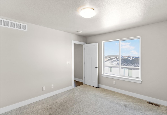 unfurnished bedroom featuring carpet, baseboards, visible vents, and a textured ceiling