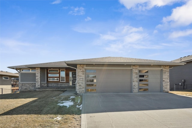 prairie-style home with a garage, stone siding, driveway, and a shingled roof