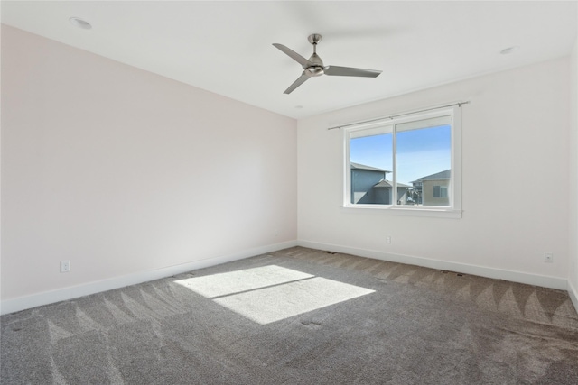 carpeted empty room with a ceiling fan and baseboards