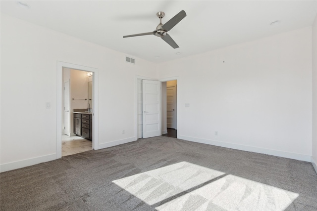 unfurnished bedroom with light colored carpet, visible vents, baseboards, and ensuite bathroom