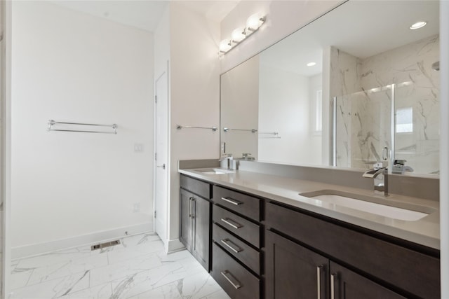 full bath with marble finish floor, a sink, baseboards, and double vanity