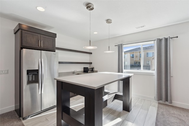 kitchen featuring open shelves, stainless steel refrigerator with ice dispenser, dark brown cabinets, and light countertops