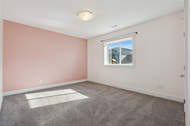 unfurnished room featuring carpet floors, visible vents, and baseboards