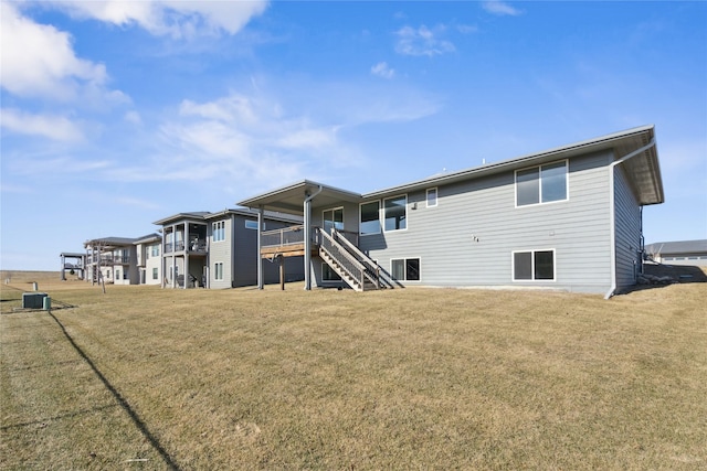 rear view of property with stairs and a yard