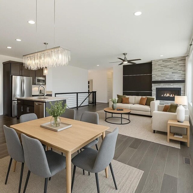 10598 NW 72nd Ln, Johnston, IA 50131 - dining area with dark wood-type flooring, ceiling fan, a fireplace, recessed lighting, and a chandelier