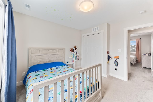 carpeted bedroom with baseboards, visible vents, and a closet