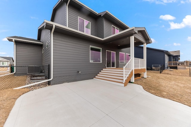 rear view of house featuring a patio area and fence