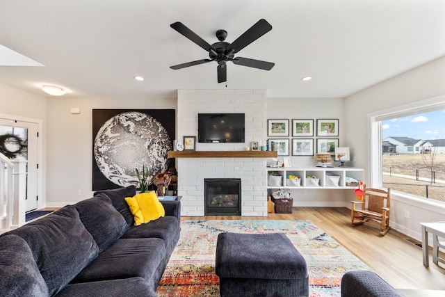 living room with baseboards, a brick fireplace, wood finished floors, and recessed lighting