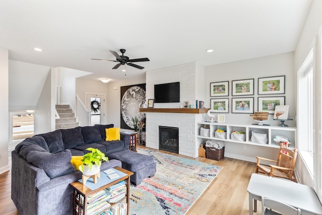 living area with a fireplace, recessed lighting, a ceiling fan, wood finished floors, and stairs