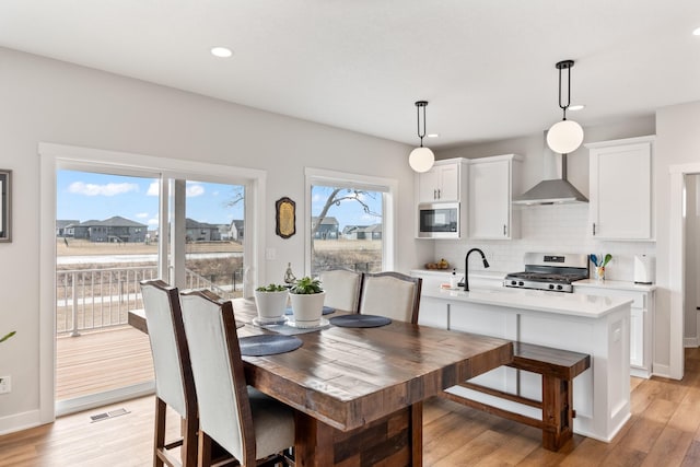 dining room with light wood-style flooring, visible vents, baseboards, and recessed lighting