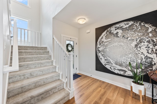 entrance foyer featuring baseboards, stairway, and light wood-style floors