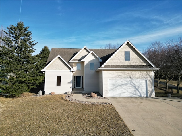 view of front of property featuring driveway, a front yard, an attached garage, and a shingled roof