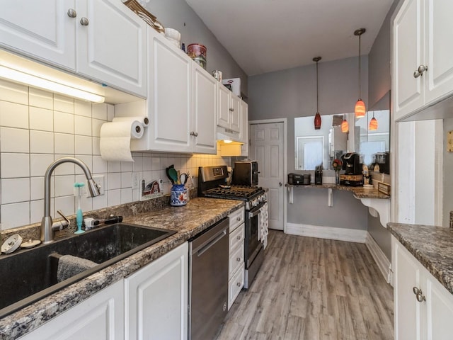 kitchen with a sink, tasteful backsplash, appliances with stainless steel finishes, and white cabinets