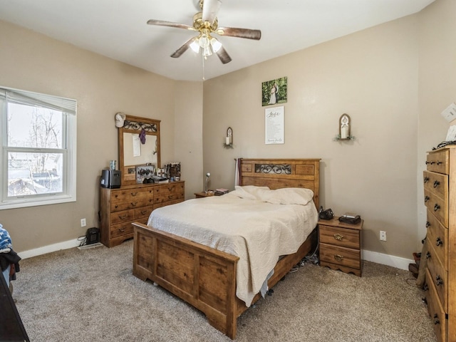 bedroom with light colored carpet, a ceiling fan, and baseboards