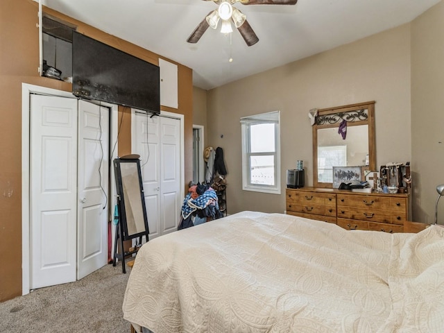 bedroom with carpet flooring, a ceiling fan, and two closets