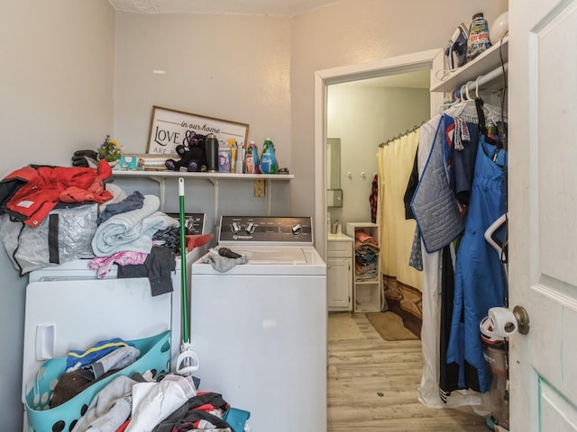 laundry area with laundry area, light wood-style flooring, and washer / clothes dryer