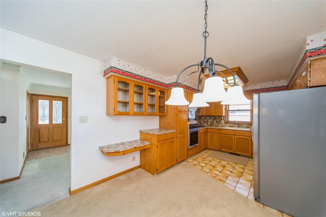 kitchen featuring light carpet, brown cabinetry, glass insert cabinets, black appliances, and a sink