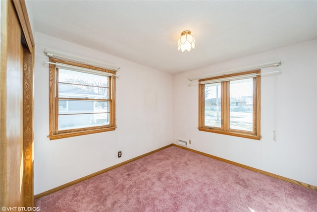 spare room with carpet and baseboards