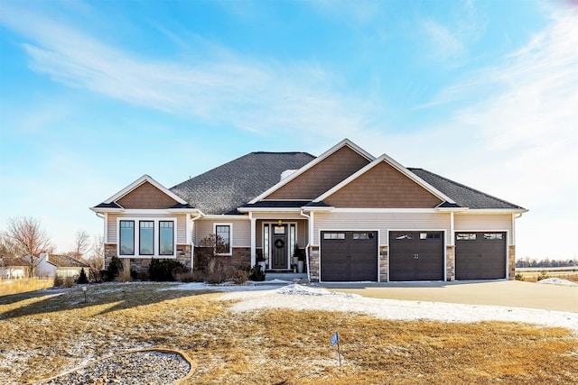 craftsman-style home with stone siding, an attached garage, and concrete driveway