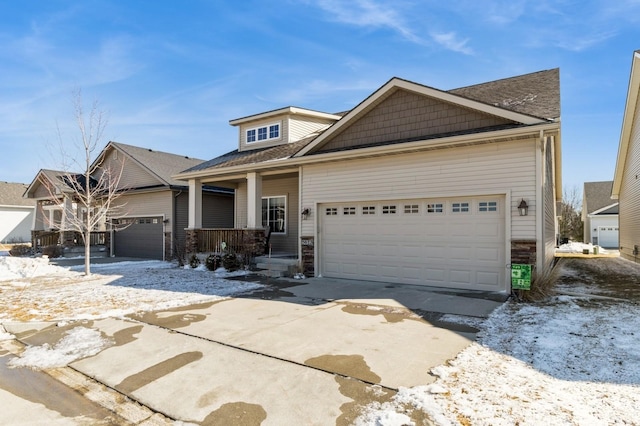 view of front of home featuring driveway, covered porch, and a garage