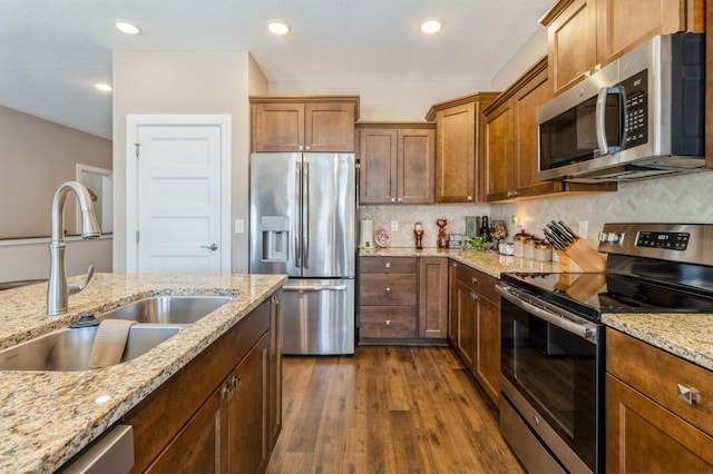 kitchen with decorative backsplash, dark wood-style flooring, stainless steel appliances, and a sink