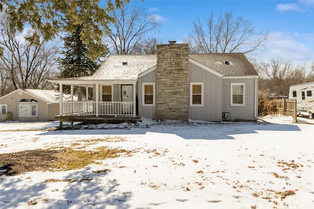 bungalow-style house with a chimney, a porch, board and batten siding, and roof with shingles