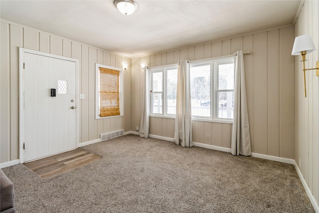 entryway featuring baseboards, visible vents, and carpet flooring