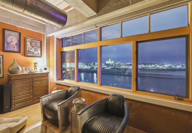 sitting room with a water view and wood finished floors