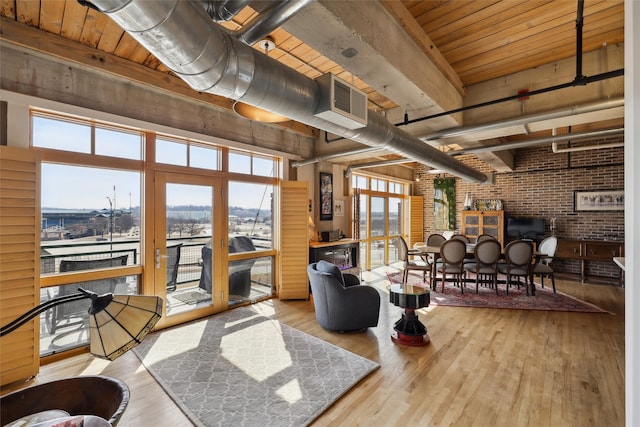 living area featuring visible vents, wood ceiling, brick wall, wood finished floors, and beamed ceiling