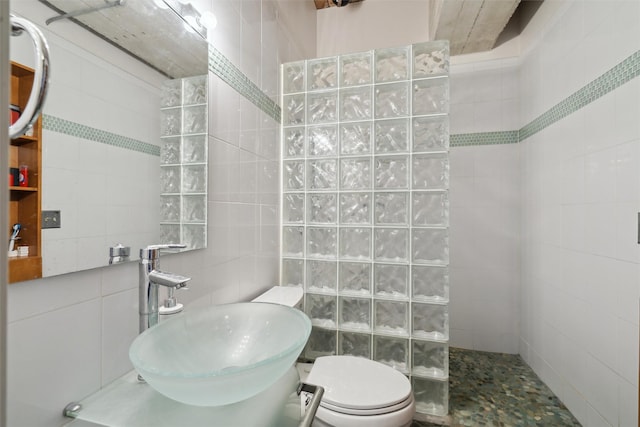 full bath featuring a walk in shower, toilet, a sink, and tile walls