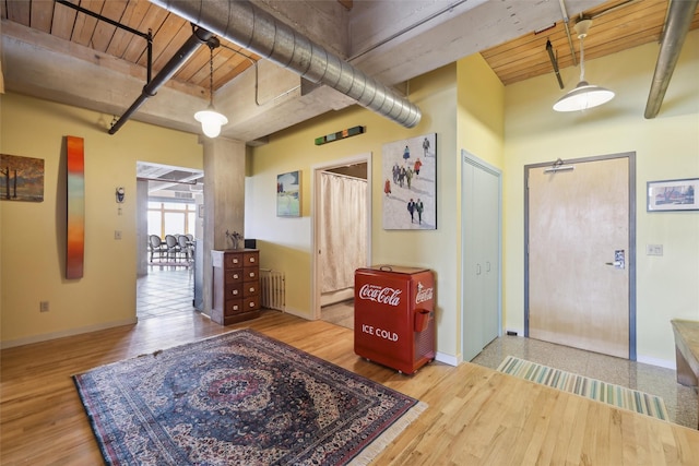 entryway featuring radiator heating unit, wood finished floors, wood ceiling, baseboards, and beamed ceiling