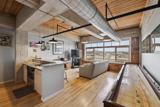 100 Market St Unit 409, 408, 407, Des Moines, IA 50309 - kitchen with light wood-style flooring, light stone counters, a peninsula, and a breakfast bar area