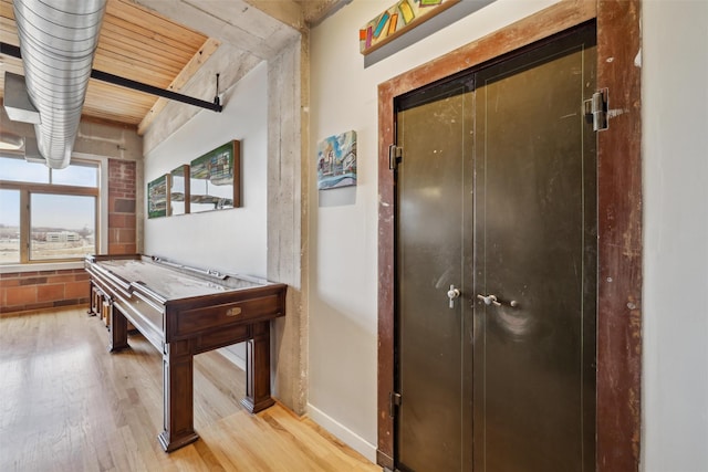 game room with baseboards and wood finished floors