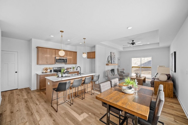 dining room featuring light wood-style floors, a tray ceiling, and recessed lighting