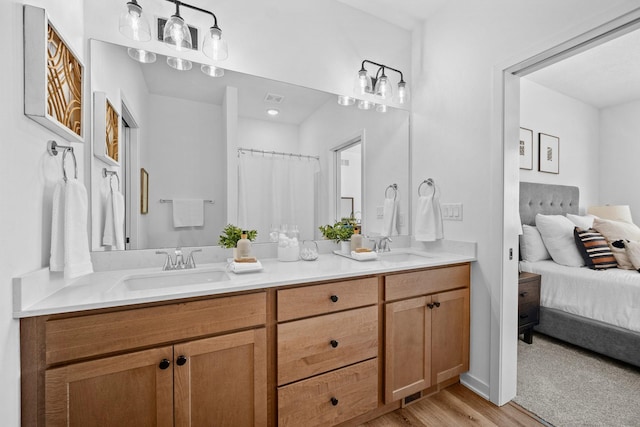 ensuite bathroom featuring visible vents, a sink, ensuite bath, and double vanity