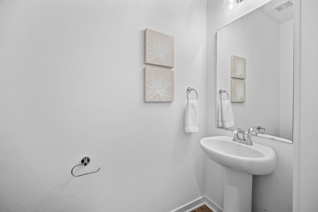 bathroom with visible vents, a sink, and baseboards