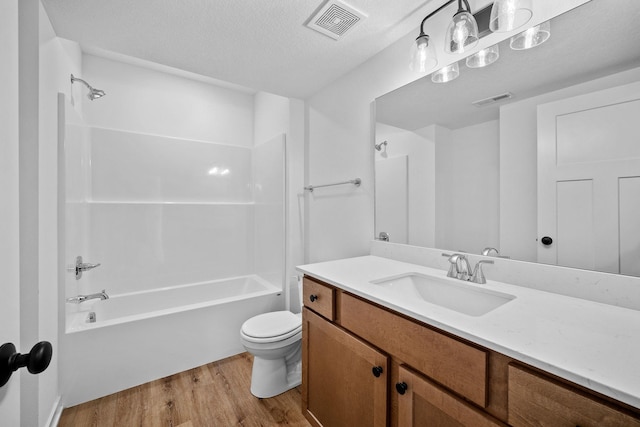 bathroom with toilet, visible vents, tub / shower combination, and wood finished floors