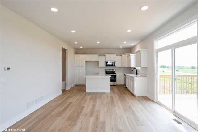 2908 Yordi Dr, Norwalk, IA 50211 - kitchen with appliances with stainless steel finishes, a sink, light wood-type flooring, baseboards, and recessed lighting