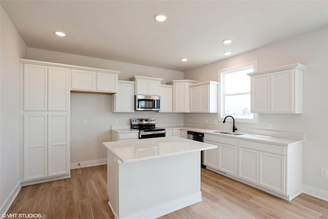 2908 Yordi Dr, Norwalk, IA 50211 - kitchen featuring appliances with stainless steel finishes, a sink, a center island, light wood-type flooring, and recessed lighting