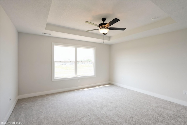 2908 Yordi Dr, Norwalk, IA 50211 - spare room featuring a raised ceiling, carpet, a ceiling fan, and baseboards
