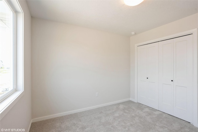 2908 Yordi Dr, Norwalk, IA 50211 - unfurnished bedroom featuring carpet flooring, a closet, and baseboards