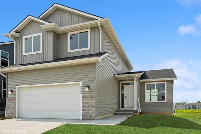 2908 Yordi Dr, Norwalk, IA 50211 - view of front of house featuring board and batten siding, an attached garage, a front yard, stone siding, and concrete driveway