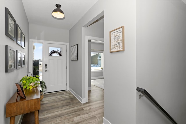 entryway with baseboards and wood finished floors