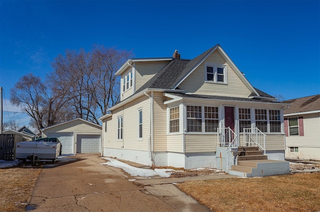 view of front of home featuring a chimney, a shingled roof, a sunroom, a garage, and an outdoor structure