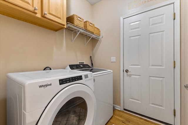 washroom featuring light wood-style floors, cabinet space, and independent washer and dryer