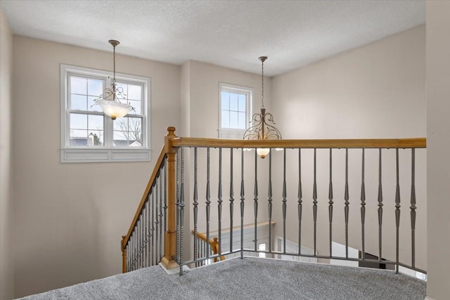 staircase featuring a textured ceiling